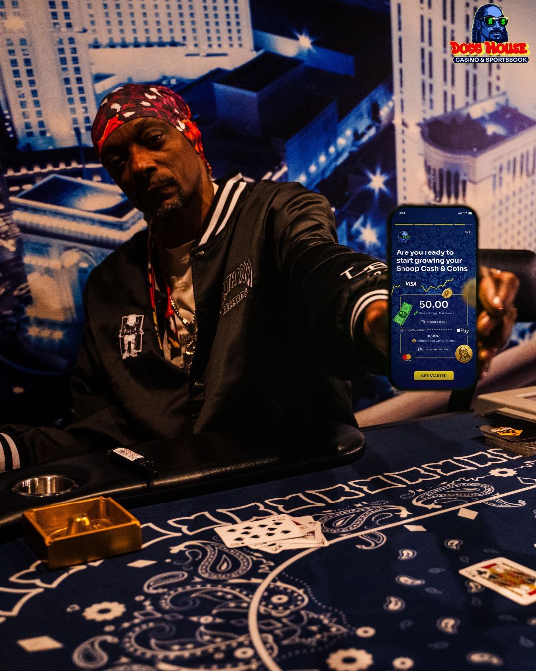 Snoop Dogg holding a phone showing his dogg house casin app.